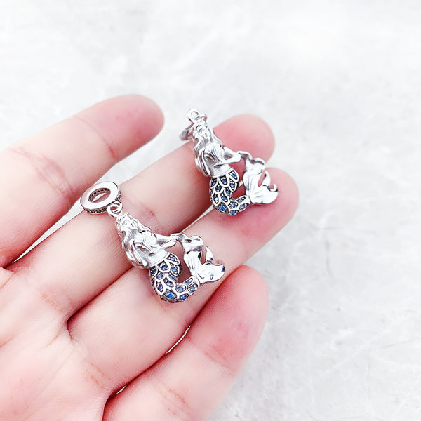Pingente Charm Sereia ira te conectar com o oceano! Traga movimento e sensualidade a sua vida!   Com um design delicado, o encanto da arquétipo da sereia simboliza a beleza, a graça e a sensualidade feminina. A sereia feita em prata 925 banhada a ródio branco representa a capacidade das mulheres de se adaptar e enfrentar qualquer desafio com determinação e sedução da sua voz.